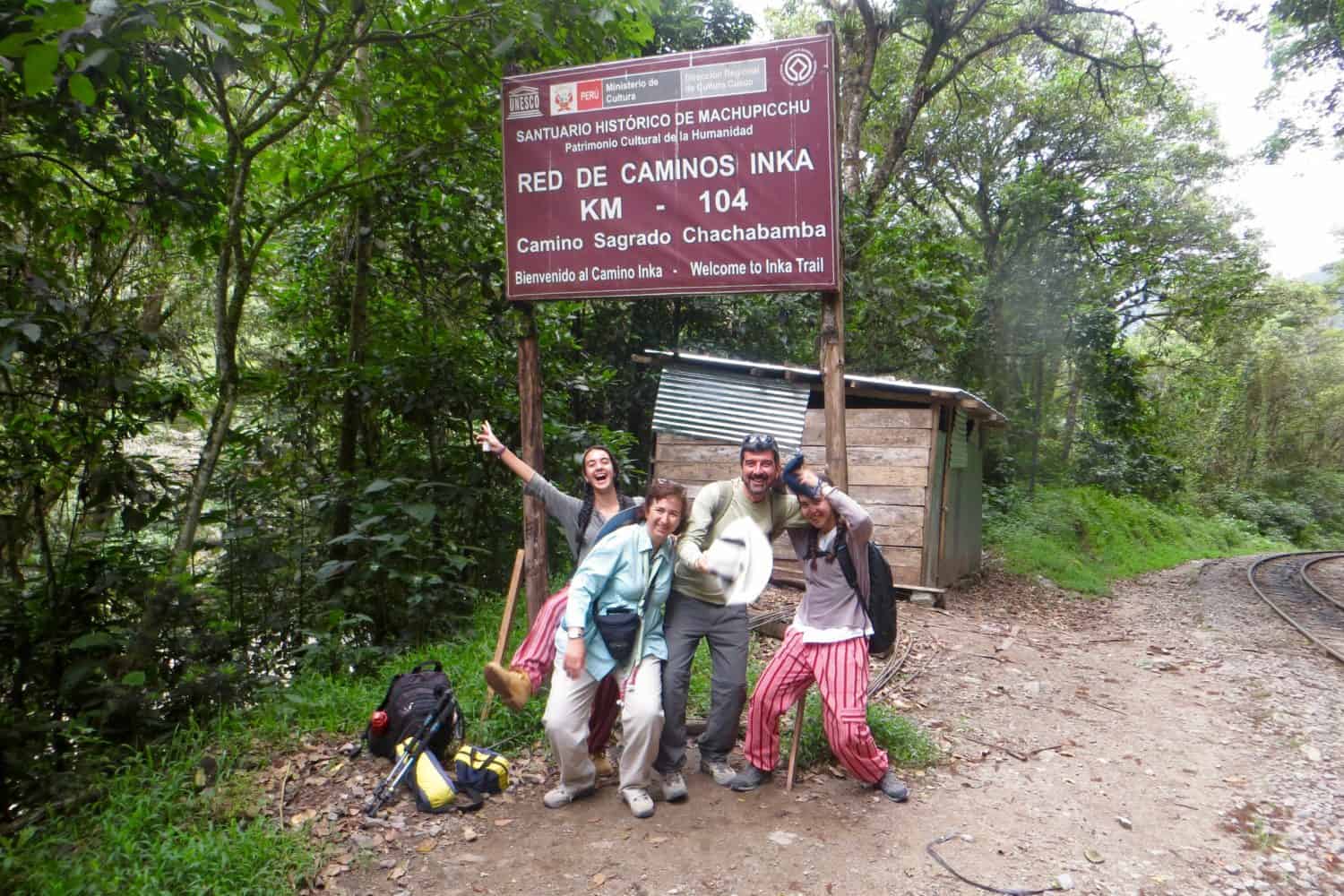 people posing in front of inca trail sign, private inca trail tour