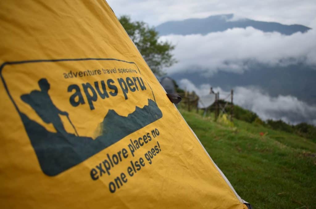 yellow tent with apus peru logo on it