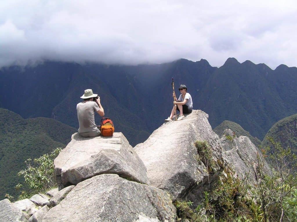 people sitting on rocks at machu picchu site, private inca trail tour