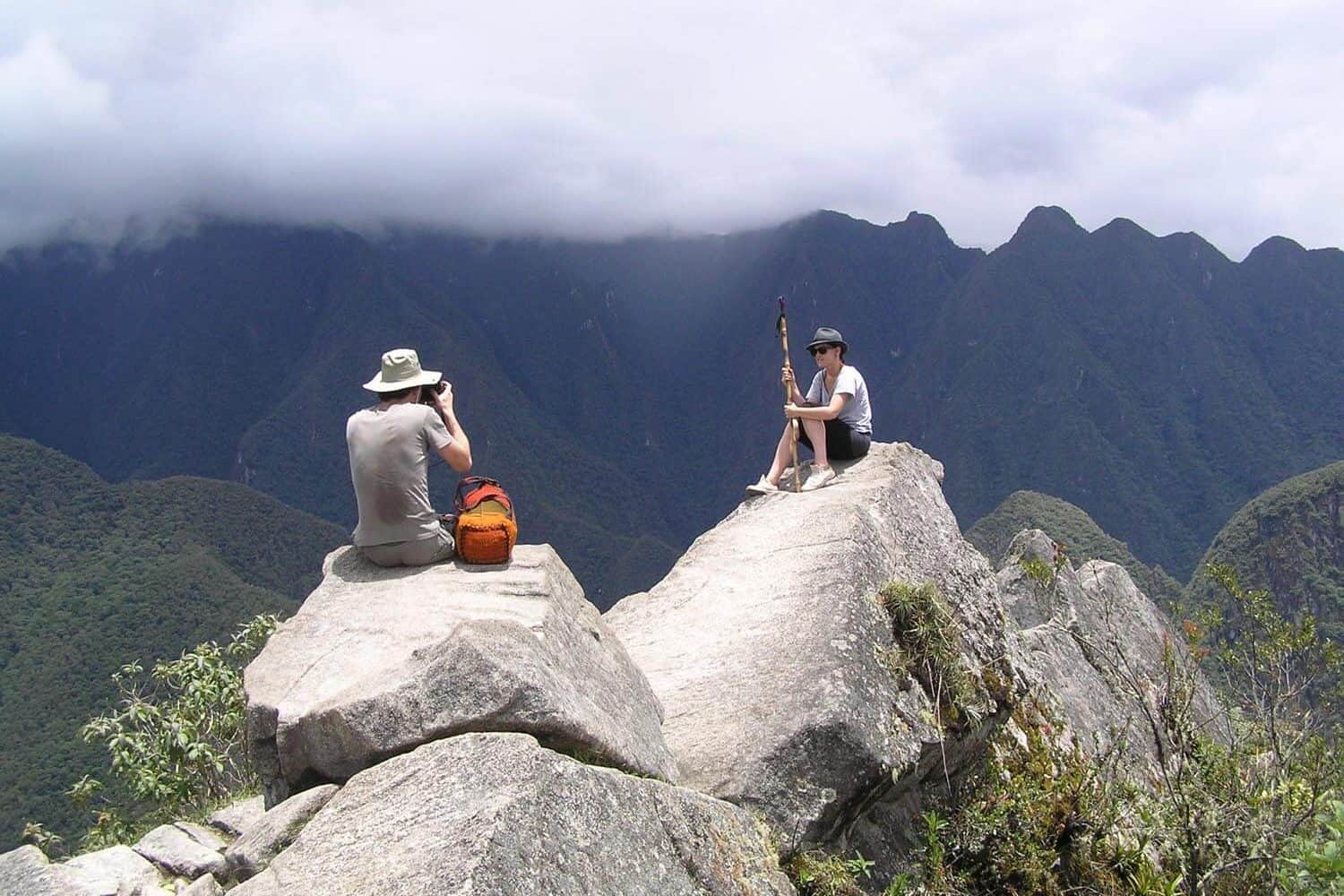 people sitting on rocks at machu picchu site, private inca trail tour