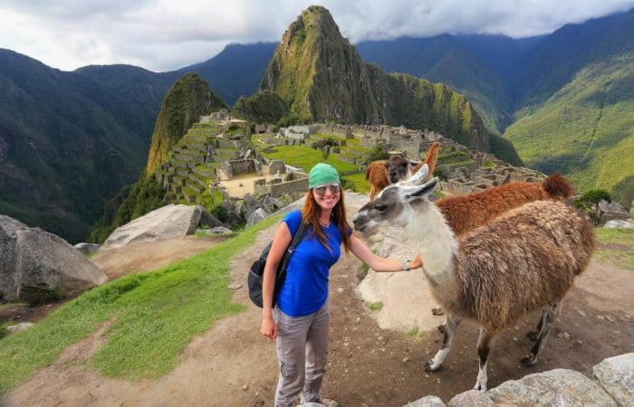 girl in front of machu picchu with llama