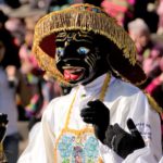 Dancer wearing a black mask during a traditional festival in the streets of Cusco, Peru