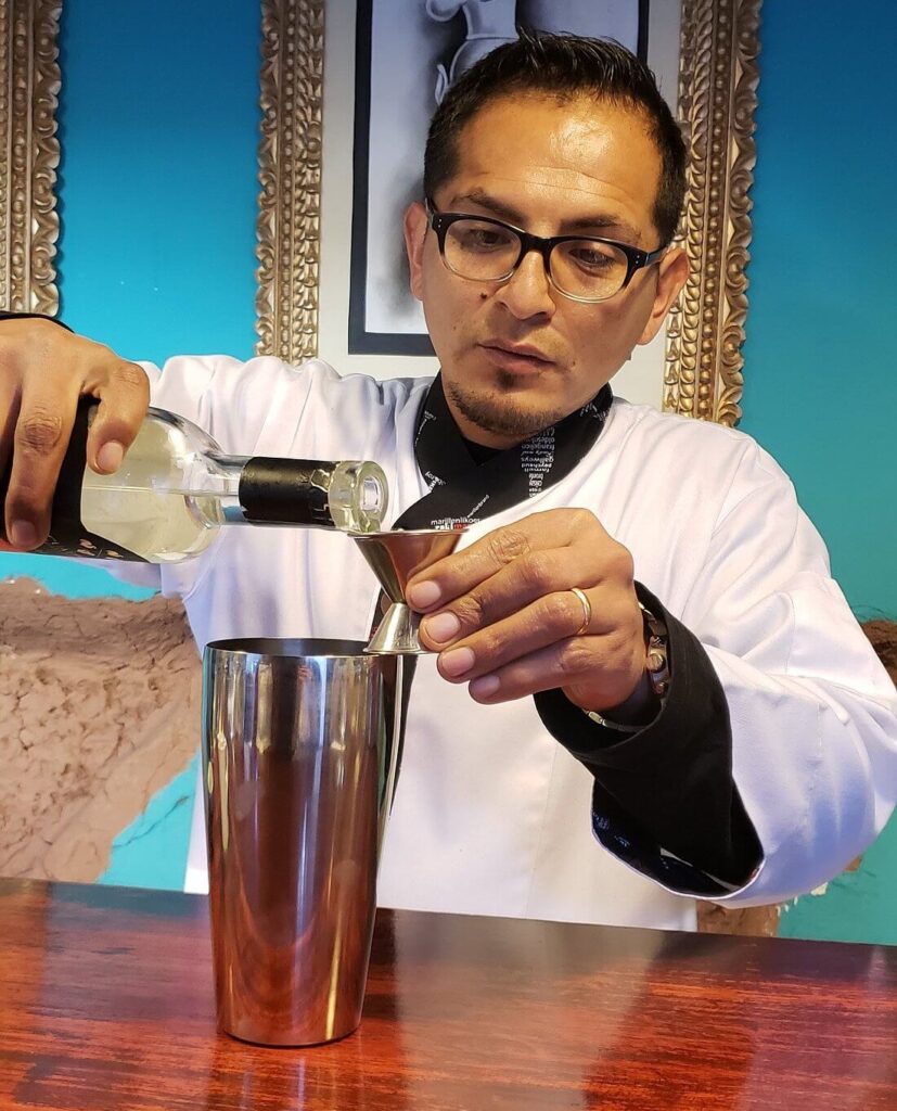 person making pisco sour in peru